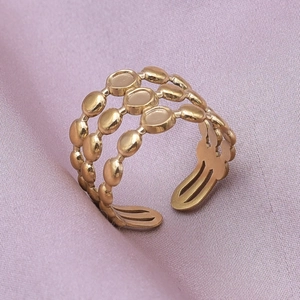 Detailed macro view of the three-layer gold beaded open adjustable ring on silk fabric