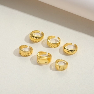 Set of six adjustable gold metal rings featuring textured wave and star designs