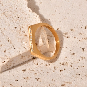 Minimalist gold titanium steel ring with D-shape paved zircon stones on a natural stone base