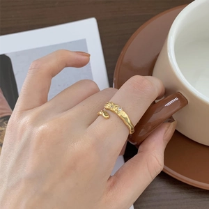 Detail of an irregular gold-plated lava ring with white zircons on a model's hand