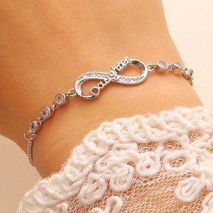 Macro shot of silver infinity bracelet with Daughter engraving and zircon stones