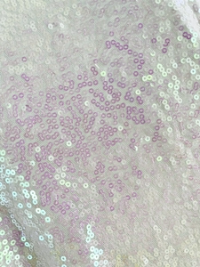 Gros plan de sequins holographiques sur maille blanche pour une robe courte sexy