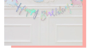 Close-up of holographic Happy Birthday banner with rainbow unicorn theme for kids