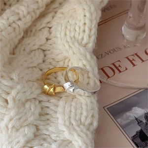 Elegant 925 sterling silver knot rings in gold and silver finish on a soft knit background