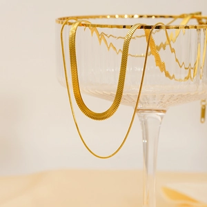 Double-layered gold titanium steel snake chain necklace for women on minimalist background