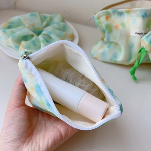 Detail of mint green watercolor cotton pouch showing zipper closure and interior storage