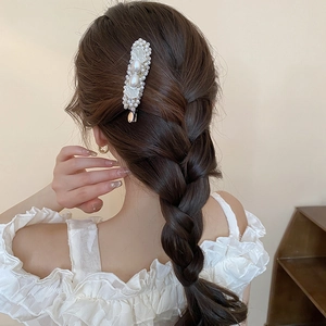 French style pearl hair clip shown on braided hair for an elegant bridesmaid hairstyle