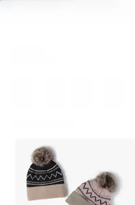 Detail of knit beanie with plush fleece lining and soft faux fur pompom texture