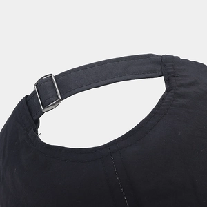 Detailed macro view of the silver metal buckle and adjustable strap on a black baseball cap