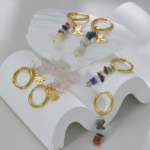 French vintage 14k gold earrings with natural stones and wings charms on white stand