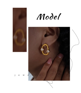 Detailed view of gold irregular hoop earrings with two rhombic cubic zirconia accents