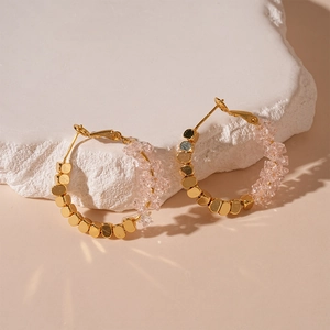 Détails de perles de cristal rose et cubes dorés sur des boucles d'oreilles créoles