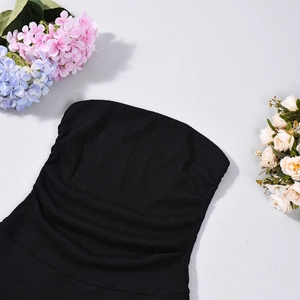 Close-up of black ribbed knit strapless dress showing vertical texture and elastic fabric