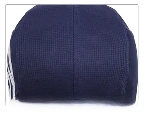 Macro view of reinforced double-stitching and grid texture on a navy blue outdoor sport cap