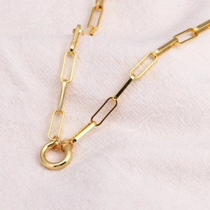 Macro shot of gold-plated paperclip chain link necklace with round connector clasp