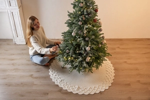 Detail of cream white cable knit Christmas tree skirt with wavy edge and woven pattern