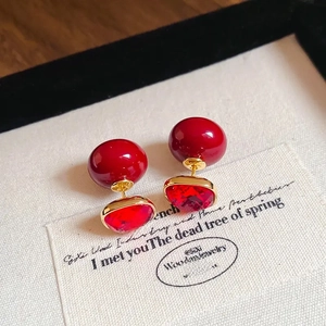 Macro shot of 18K gold plated square earrings with red beads and faceted rubies