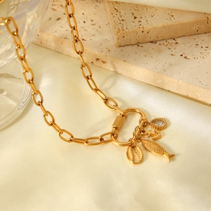 Collier à maillons dorés orné de pendentifs marins tels qu'un poisson et une ancre