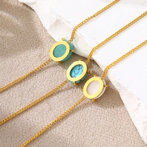 Detailed view of three gold link necklaces with green, turquoise, and white oval stones
