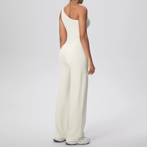 Détail du haut à une épaule et du pantalon large à taille haute en blanc crème