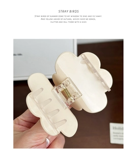Detailed back view of a beige flower hair claw clip with its durable metal spring and teeth