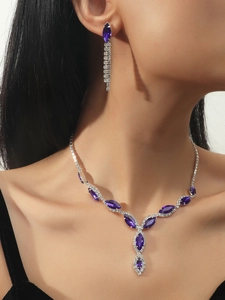 Close-up of elegant bridal jewelry set with purple crystals on a silver necklace