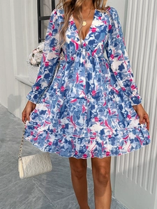 Detail of elegant V-neck floral dress with blue, white, and red pattern and ruffled hem