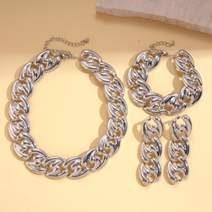 Silver Cuban link necklace set with bracelet and earrings on minimalist stone props