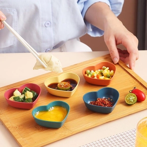Five heart-shaped wheat straw dipping sauce bowls in vibrant colors for kitchen use