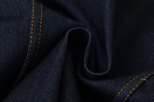 Vue macro détaillée du tissu denim bleu foncé avec coutures contrastées jaunes