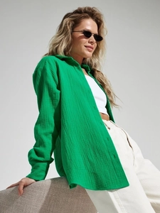 Detailed texture of green long sleeve cotton crepe shirt fabric on model