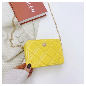 Detailed shot of yellow PVC jelly bag featuring diamond quilted texture and golden chain