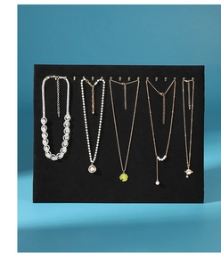 Macro detail of high-quality black velvet necklace display board with metal hanging hooks