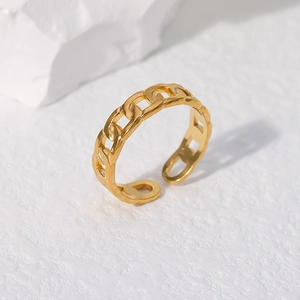 Detail of adjustable gold chain ring made of durable stainless steel on a textured surface