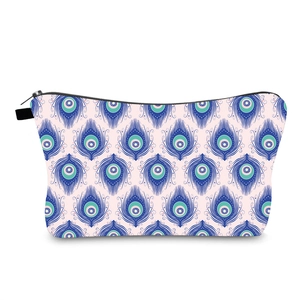 Water-resistant travel makeup bag with colorful blue peacock feather pattern and side handle