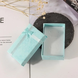 Elegant light blue rectangular jewelry gift box with a silk ribbon bow and white liner