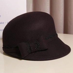 Detailed texture of dark brown wool cloche hat with black lace and rhinestone bow