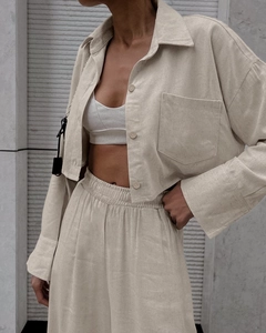 Detail of beige long sleeve crop shirt and high-waisted wide leg pants linen set
