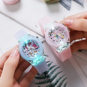 Close-up of luminous LED children watches with silicone strap and glowing unicorn pattern