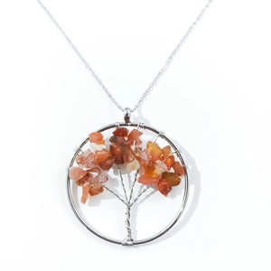 Detailed macro view of the silver wire wrapped Tree of Life pendant with red crystals