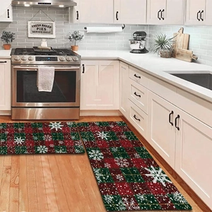 Detail of red and green plaid Christmas kitchen rugs set with white snowflake patterns