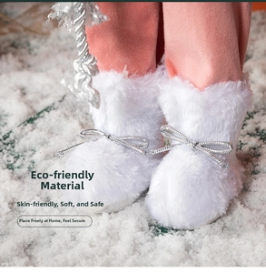 Detail of pink Santa doll boots with white faux fur and silver bow on snow background