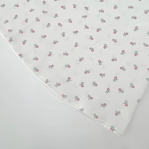Detail of floral print fabric with neat stitching on a vintage white long-sleeve dress