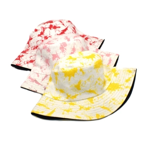 Close-up of tie-dye bucket hats in red, pink and yellow with thick cotton fabric texture