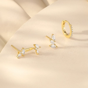 Macro shot of gold-plated S925 silver earring set with white zircon leaf studs