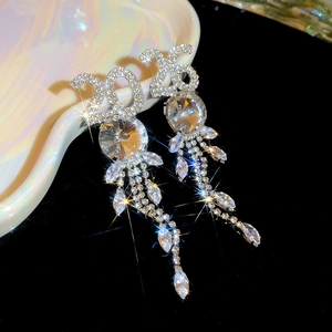 Gros plan de boucles d'oreilles 2025 à pampilles en strass argentés sur plateau céramique