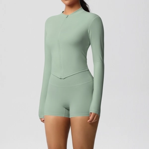 Detail of a two-piece yoga set with a slim-fit zipper jacket and high-waist shorts in sage green
