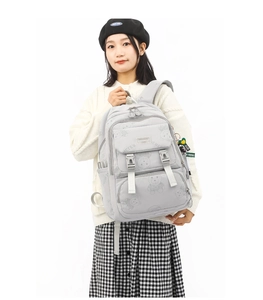 Detail of light grey school backpack with bear prints and adjustable buckle straps