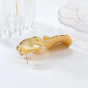 Detailed close-up of golden irregular petal earrings featuring metallic pleated textures