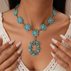 Gros plan du collier vintage en résine avec pierres turquoise sur chaîne dorée